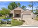 Charming one-story home with a paver driveway, two-car garage, manicured lawn and lovely landscaping at 2235 Lytham Ct, Spring Hill, FL 34606