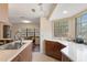 Bright kitchen with white countertops, wood cabinets and a view into the dining area at 2235 Lytham Ct, Spring Hill, FL 34606