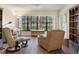 Cozy living room featuring hardwood floors, built-in shelving, and a lovely water view at 2235 Lytham Ct, Spring Hill, FL 34606