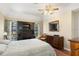 This main bedroom has classic furnishings, ceiling fan, and built-in desk overlooking the rear yard at 2235 Lytham Ct, Spring Hill, FL 34606