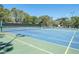 Blue and green tennis courts surrounded by mature trees at 2235 Lytham Ct, Spring Hill, FL 34606