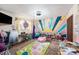 Charming bedroom with colorful mural, playful rug, and lots of sunlight streaming in from the window at 2254 Coachman Rd, Spring Hill, FL 34608