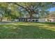 A single-story home with a large front yard with grass and shade trees at 2254 Coachman Rd, Spring Hill, FL 34608
