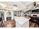 Modern kitchen with an island featuring bar seating, stainless steel appliances, and a view of the dining area at 2254 Coachman Rd, Spring Hill, FL 34608