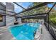 Inviting screened-in pool featuring clear water and a peaceful backyard, perfect for outdoor relaxation and entertainment at 2254 Coachman Rd, Spring Hill, FL 34608