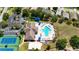 Overhead shot of the clubhouse with pool, tennis courts, and community amenities surrounded by greenery at 2325 Pleasant Hill Ln, Holiday, FL 34691