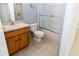 Bright bathroom with oak vanity, toilet, and tiled shower at 2325 Pleasant Hill Ln, Holiday, FL 34691