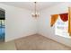 Bright dining room with plush carpet, hanging chandelier, and natural light from the window at 2325 Pleasant Hill Ln, Holiday, FL 34691