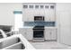 Stylish kitchen with white cabinets, stainless steel appliances, and vibrant backsplash at 2325 Pleasant Hill Ln, Holiday, FL 34691