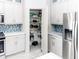 Modern kitchen features white cabinetry, stainless steel appliances, and a pantry at 2325 Pleasant Hill Ln, Holiday, FL 34691