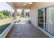 Relax on the screened porch with tile floors, ceiling fan, and sliding doors to the backyard at 2325 Pleasant Hill Ln, Holiday, FL 34691