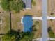 Aerial view shows a compact, well maintained property with a vibrant blue roof and a neat driveway at 27198 Simona Ave, Brooksville, FL 34602