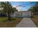 Charming single-story home with a well-maintained lawn, complemented by a mature palm tree and private driveway at 27198 Simona Ave, Brooksville, FL 34602