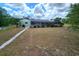 Exterior of home with a spacious yard, lush landscaping, and beautiful patio area at 273 Gulfport Ln, Spring Hill, FL 34608