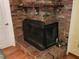 Close up of a red brick fireplace with a decorative shelf and protective screen at 273 Gulfport Ln, Spring Hill, FL 34608