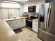 Kitchen with white cabinets, stone countertops, stainless steel appliances, and a large window at 273 Gulfport Ln, Spring Hill, FL 34608