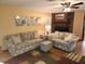 Comfortable living room featuring two sofas, ottoman, brick fireplace and neutral paint at 273 Gulfport Ln, Spring Hill, FL 34608