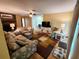 Spacious living room featuring a brick fireplace, a ceiling fan, and a colorful area rug at 273 Gulfport Ln, Spring Hill, FL 34608