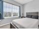 Bedroom featuring a large window, neutral walls, and a bed with a dark wood headboard at 2815 Dudley Ave, Odessa, FL 33556