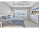 Bright bedroom with a tray ceiling, ceiling fan, and large windows that let in plenty of natural light at 2815 Dudley Ave, Odessa, FL 33556