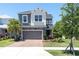 Inviting two-story home featuring a brick driveway, stone accents, gray painted facade, and well-manicured landscaping at 2815 Dudley Ave, Odessa, FL 33556