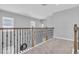 Carpeted hallway featuring wooden railings and black iron spindles overlooking the lower level at 2815 Dudley Ave, Odessa, FL 33556
