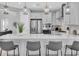 Bright kitchen showcasing white cabinets, stainless appliances, counter seating, and seamless flow to the living area at 2815 Dudley Ave, Odessa, FL 33556