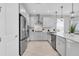 Modern kitchen featuring stainless steel appliances, white cabinets, and ample counter space for cooking and entertaining at 2815 Dudley Ave, Odessa, FL 33556