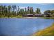 Beautiful lakefront view of community clubhouse, white sand beach, and tall trees at 2815 Dudley Ave, Odessa, FL 33556