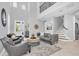 Bright living room with soaring ceilings, sleek furniture, and a staircase leading to the upper level at 2815 Dudley Ave, Odessa, FL 33556