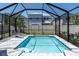 Sparkling pool with screened in patio, surrounded by lush landscaping, ideal for relaxation at 2815 Dudley Ave, Odessa, FL 33556