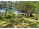 This backyard offers lush landscaping, shade trees, and partial fencing for outdoor living at 3029 Harrow Rd, Spring Hill, FL 34606
