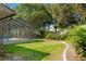 Relax in this backyard, complete with mature trees, partial fencing, and a pool enclosure at 3029 Harrow Rd, Spring Hill, FL 34606
