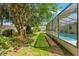 This backyard has a view of mature trees and an enclosed pool for outdoor enjoyment at 3029 Harrow Rd, Spring Hill, FL 34606