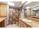 Well-lit bathroom with a sink, toilet, shower with curtain, and ample counter space at 3029 Harrow Rd, Spring Hill, FL 34606
