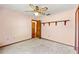 Cozy bedroom with pink walls, carpet, a ceiling fan, and an ensuite bathroom at 3029 Harrow Rd, Spring Hill, FL 34606