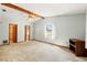 Spacious bedroom with neutral carpet, wood beam ceiling and a window overlooking a lake at 3029 Harrow Rd, Spring Hill, FL 34606