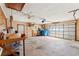 Spacious garage featuring shelving, a work bench, a ceiling fan, and a multi-panel garage door with window inserts at 3029 Harrow Rd, Spring Hill, FL 34606
