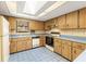 Bright kitchen with plenty of wood cabinets, classic appliances, blue tile floor, and a large skylight at 3029 Harrow Rd, Spring Hill, FL 34606