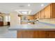 A classic, well-lit kitchen with wood cabinets, blue countertops, modern appliances, and tile floors at 3029 Harrow Rd, Spring Hill, FL 34606