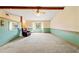 An expansive living room with unique wall-coverings, carpeted floors, a corner window, and natural light at 3029 Harrow Rd, Spring Hill, FL 34606