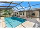 Enjoy this backyard pool featuring a screened-in enclosure and adjacent patio space at 3029 Harrow Rd, Spring Hill, FL 34606