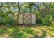 This backyard shed offers extra storage space and is surrounded by lush landscaping at 3029 Harrow Rd, Spring Hill, FL 34606