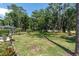 Spacious backyard with lush greenery and screened-in lanai, ideal for outdoor activities at 3047 Bolt Dr, Palm Harbor, FL 34685