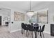 A modern dining room is set with a black table, black chairs, and a stunning crystal chandelier at 3047 Bolt Dr, Palm Harbor, FL 34685