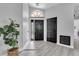 Inviting foyer with wood-look floors, a decorative plant, and a modern light fixture at 3047 Bolt Dr, Palm Harbor, FL 34685
