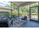 Comfortable screened-in lanai with cozy seating, perfect for relaxation and enjoying nature at 3047 Bolt Dr, Palm Harbor, FL 34685