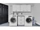 Well-equipped laundry room with white cabinets and modern washer and dryer units at 3047 Bolt Dr, Palm Harbor, FL 34685