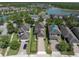 Aerial view of homes with brick driveways, landscaped yards, and access to a nearby lake at 3057 Riders Pass, Odessa, FL 33556