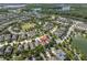 Aerial view of a residential area near lakes, showcasing neatly arranged homes with verdant trees and landscaped yards at 3057 Riders Pass, Odessa, FL 33556